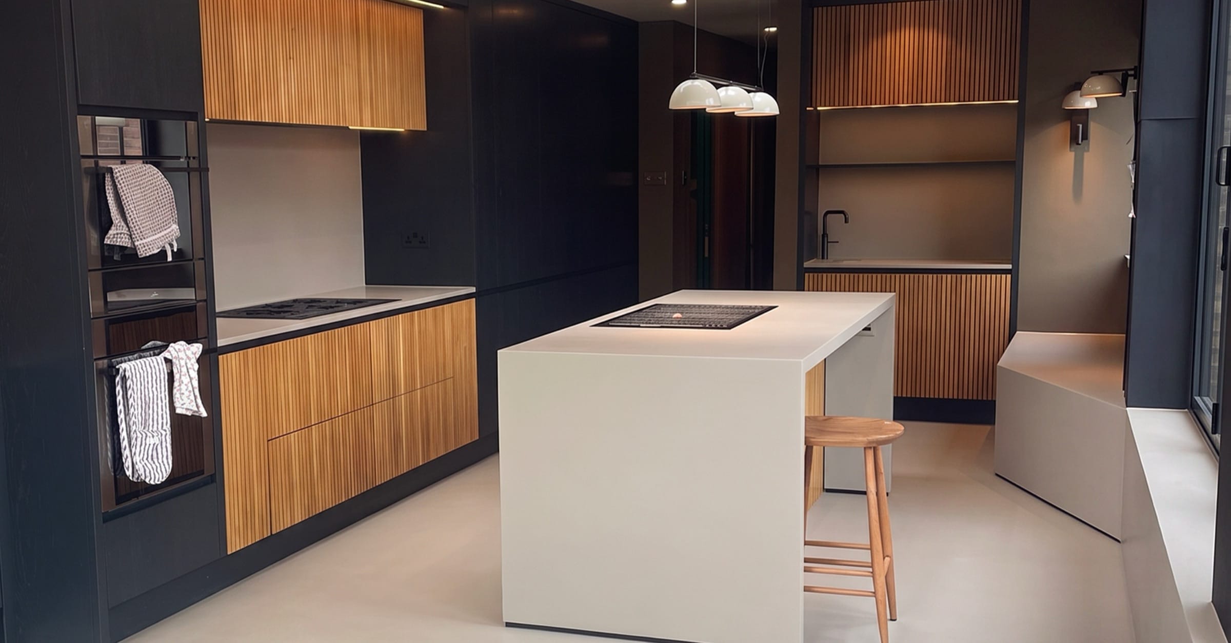 Seamless microcement kitchen floor with timber-slatted cabinetry, St Mary's Road, Leamington Spa